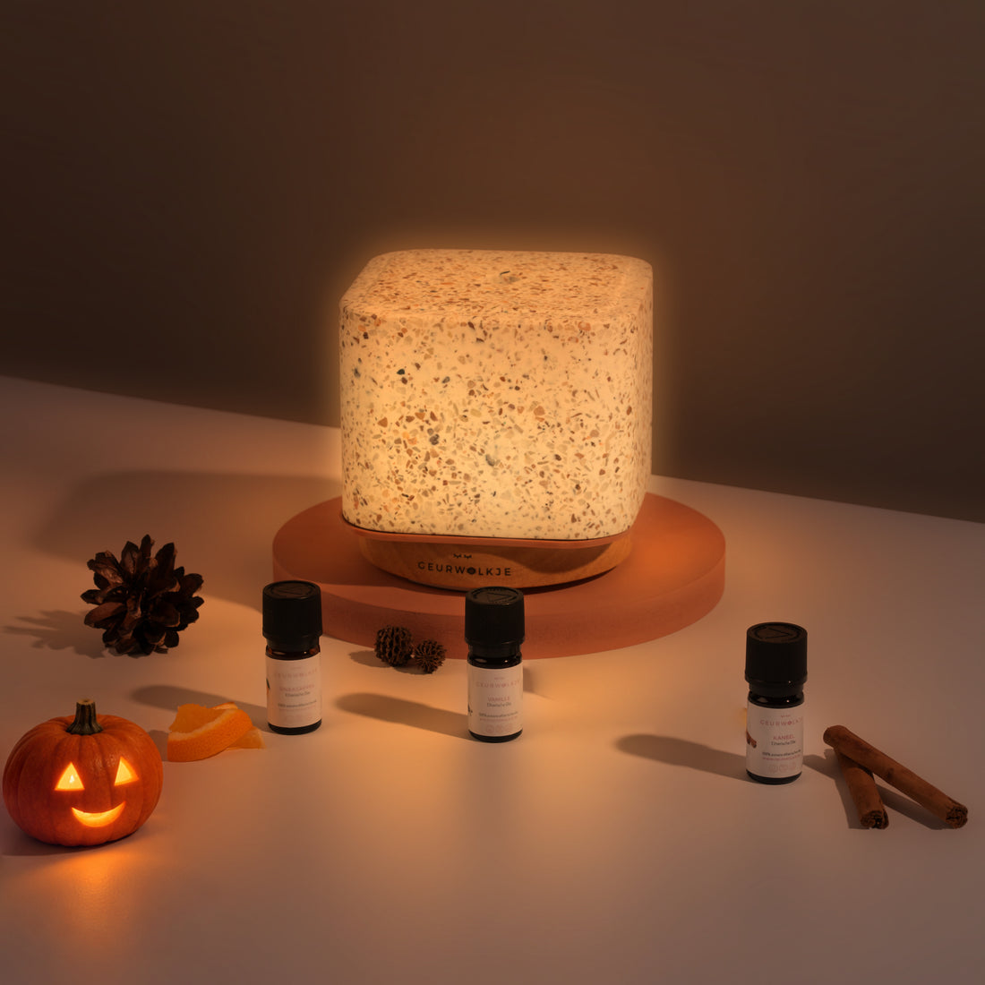 Pumpkin Spice bundel met Living Green Terrazzo Kubus, Kaneel, Sinaasappel en Vanille bij avondlicht met Halloween-pompoen.