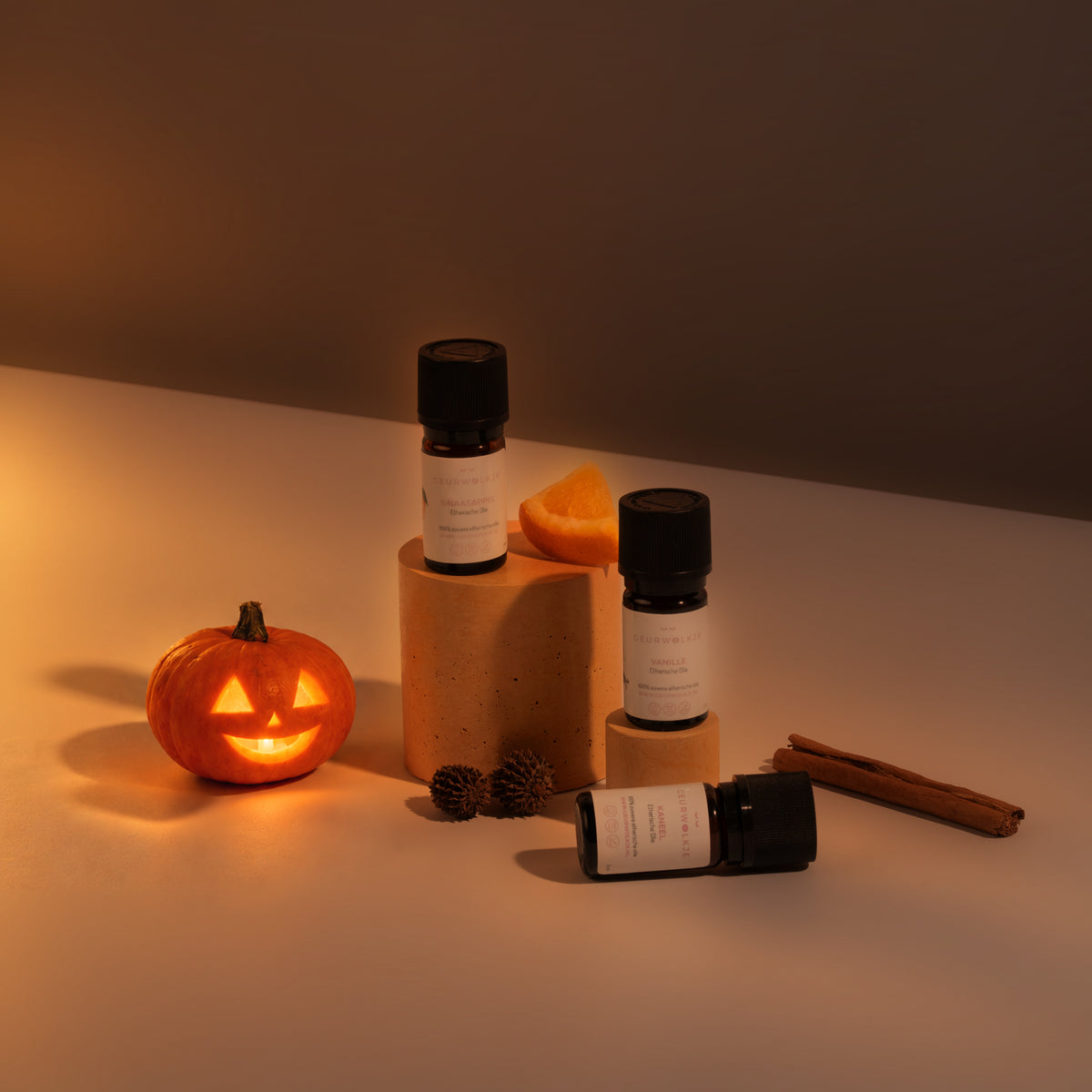 Pumpkin Spice bundel met Kaneel, Sinaasappel en Vanille bij avondlicht met Halloween-pompoen.