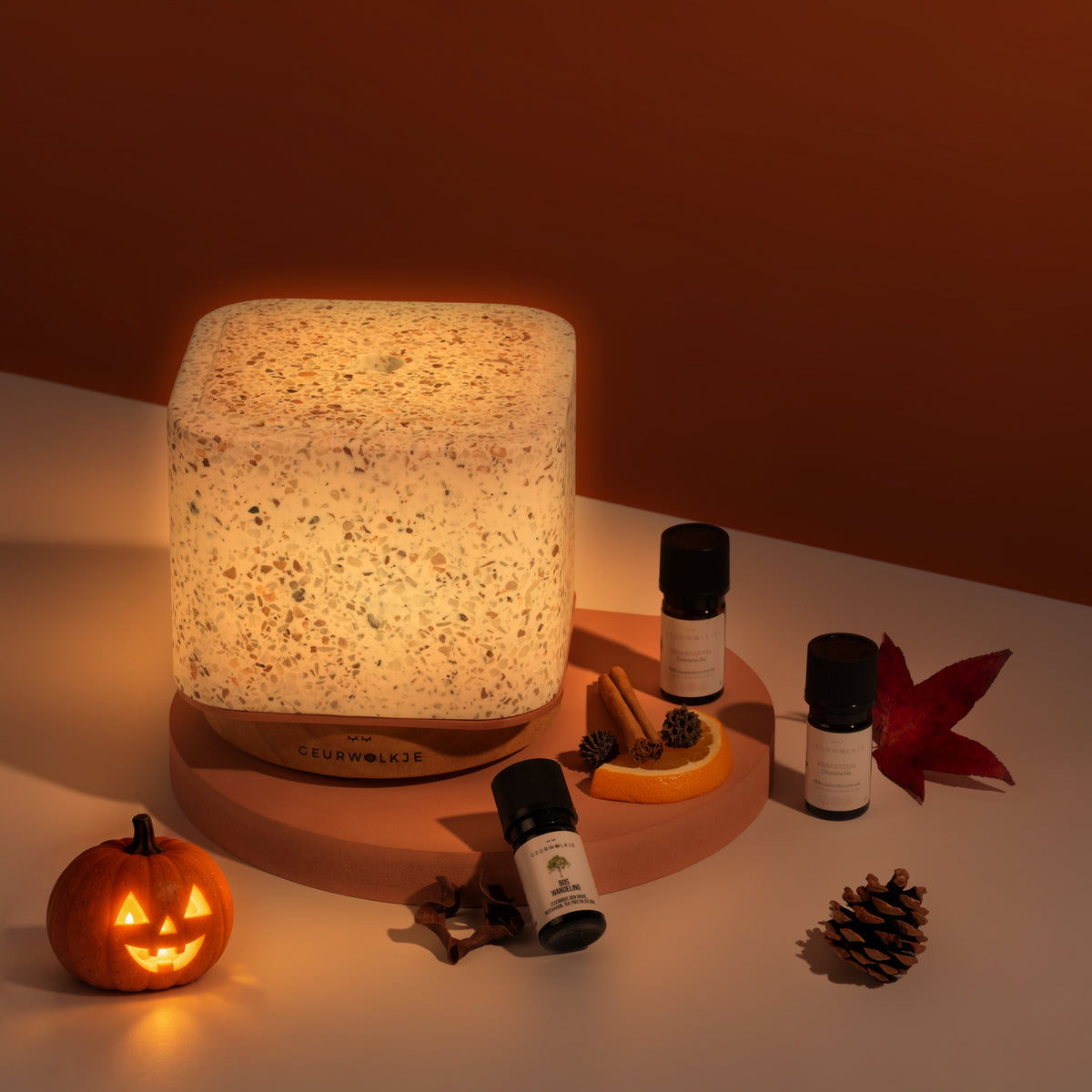 Herfstbundel met Living Green Terrazzo Kubus, Herfstzon, Boswandeling en Sinaasappel bij avondlicht met Halloween-pompoen.
