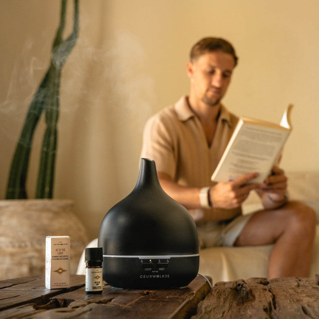 Zwarte Geurwolkje diffuser met etherische olie tijdens een rustig leesmoment