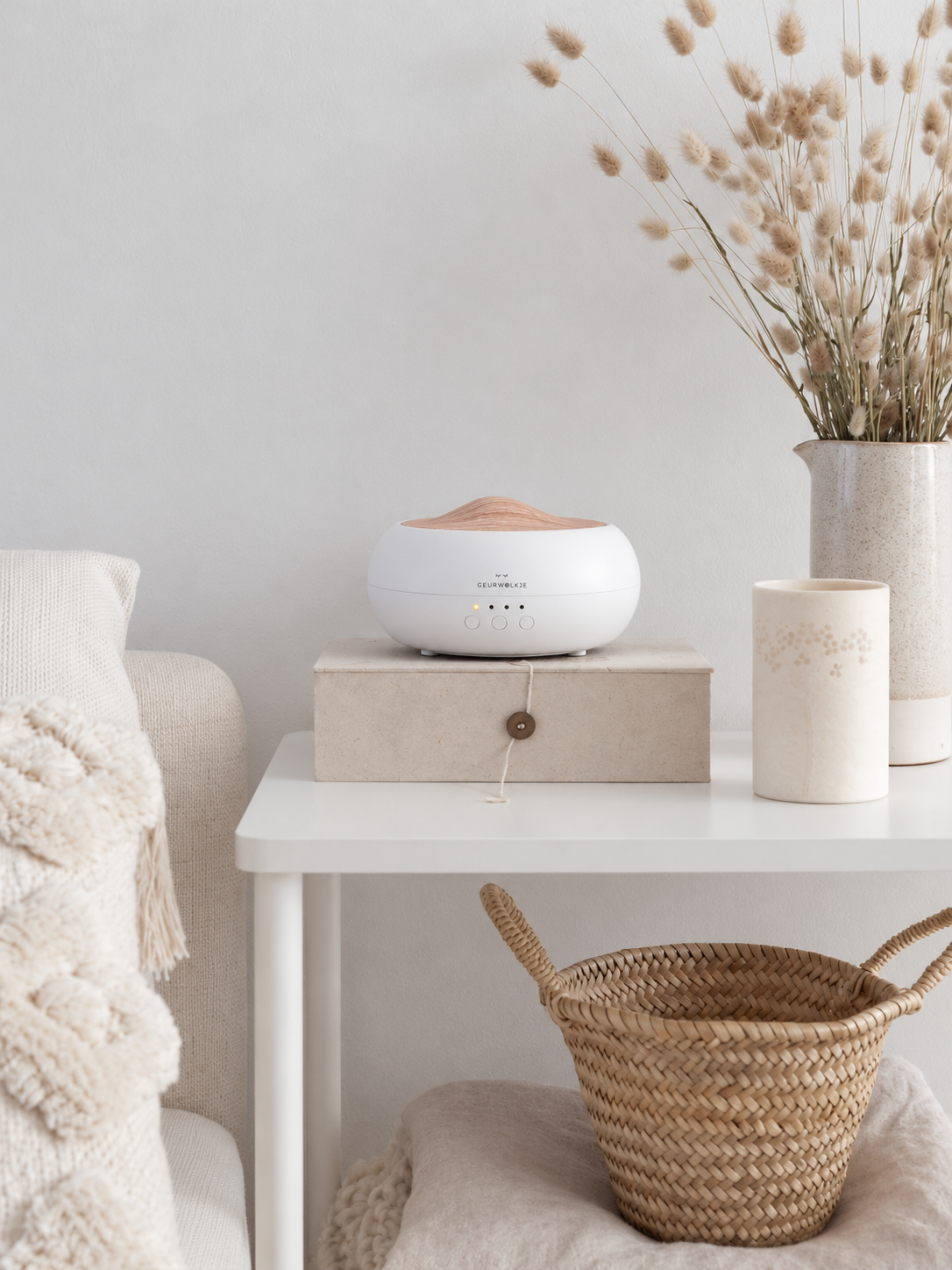 Sakura Geurwolkje aroma diffuser wit op een bijzettafel naast een vaas met droogbloemen